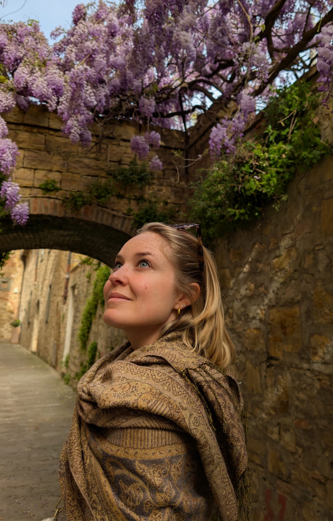 Chantal souriante sous des glycines